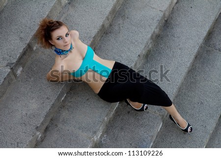 attractive futuristic girl with beautiful makeup lying on stairs