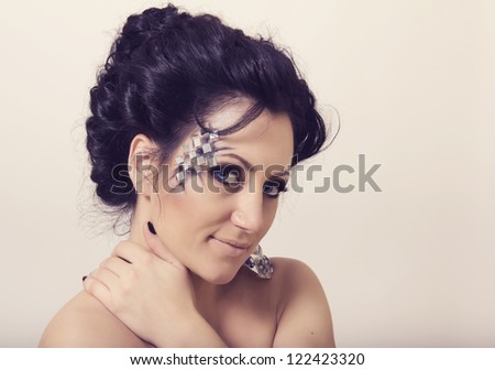 Beautiful young woman with classical hairstyle and creative make up