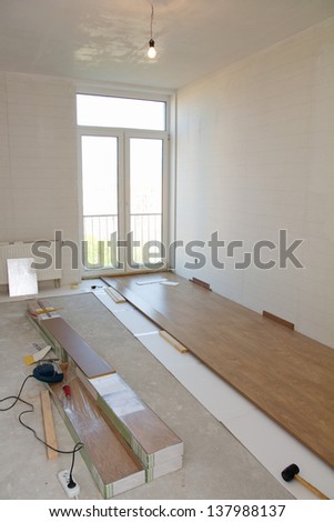 Empty room with laminate flooring and tools