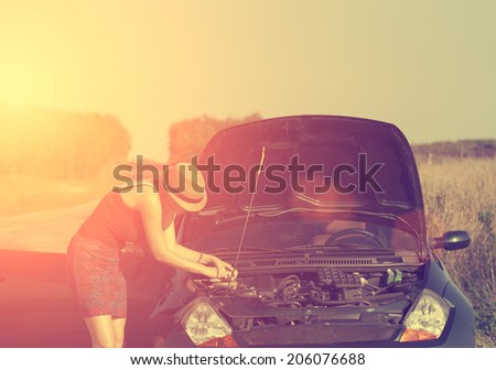 Vintage photo of woman with broken down car in summer sunset