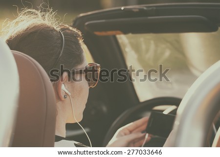 Retro photo of woman listening music in car while driving