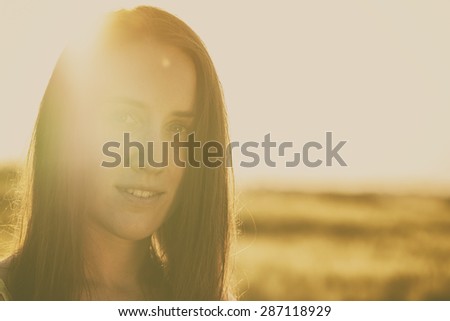 It is summertime. Beautiful woman in summer sunset