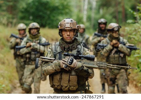 soldier stands with arms together with other