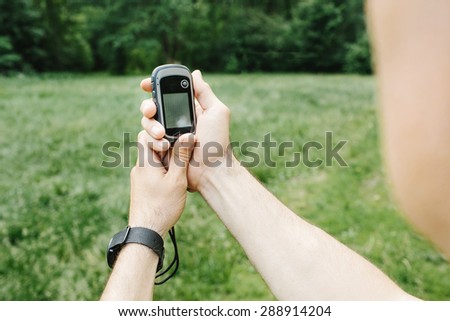 Man holding a GPS receiver and plan in his hand. Handheld GPS devices are used predominantly in the outdoor leisure industry for walking and hiking.