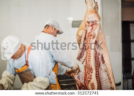 butcher chopping pork meat in meat industry