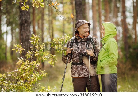 Hiking - Hikers walking in forest with poles on path in mountains. Close up of hiker shoes boots and hiking sticks poles. Man and woman hiking together.