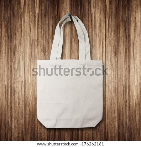 White cotton bag hanging on a wooden wall