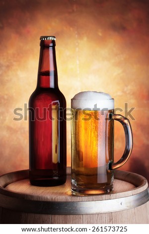 Bottle and glass of beer on a wooden barrel