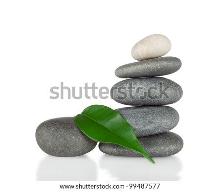 The pyramid of round stones with green leaf isolated on white background Foto stock © 