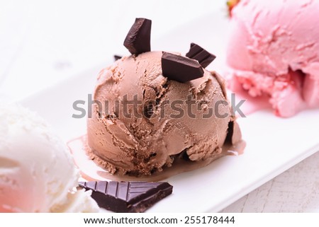 three scoops of ice cream ( chocolate , vanilla , strawberry )