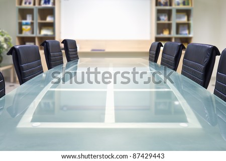 Meeting room with glass top table and armchairs, office interior