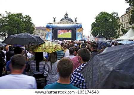LVIV, UKRAINE - JUNE 10: In the Lvov Fan-zone on Euro-2012, spectators watching a football match in the rain - Ireland-Croatia on June 10, 2012 in Lviv, Ukraine.