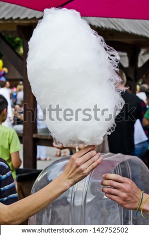 Cotton candy from hand to hand close-up
