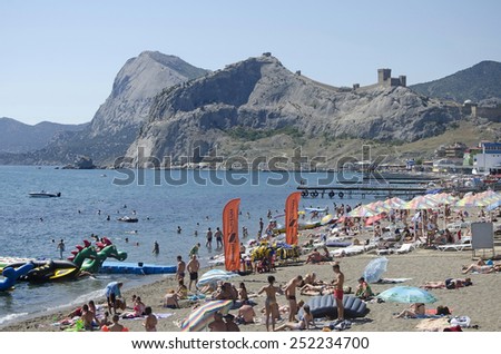 SUDAK, CRIMEA, RUSSIA - AUGUST 24: Tourists resting on the beach on august 24, 2014 in Sudak, Crimea, Russia