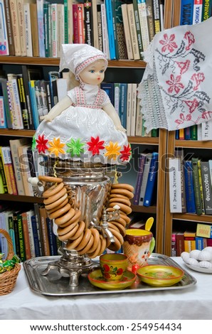 KERCH, CRIMEA, RUSSIA - FEBRUARY 22: A doll sits on top of the samovar where bagels are hung in the library of Ostrovsky during the celebration of carnival on February 22, 2015 in Kerch, Crimea, Russia