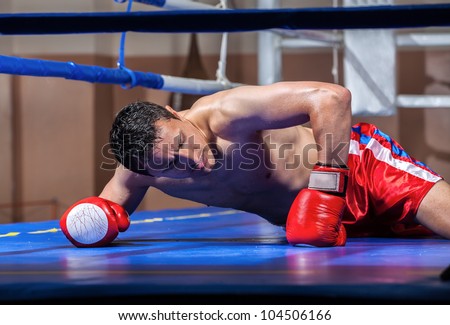 boxer lying knocked out in a boxing ring