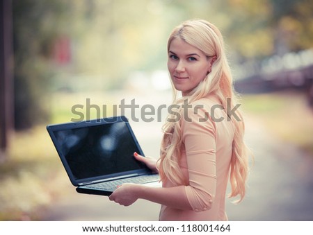 Cute woman with laptop in the park