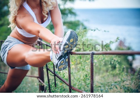 Young fitness woman stretching muscles before sport activity - outdoor in park