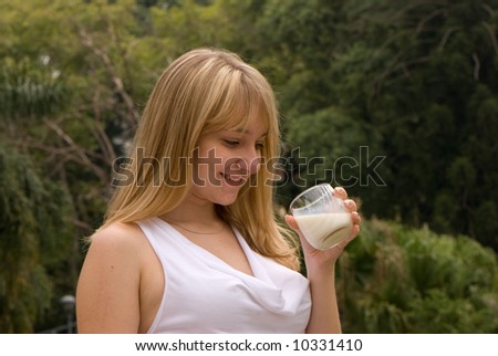 The girl drinking milk on the nature