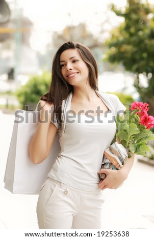 The beautiful young girl with a shopping Bag and flower