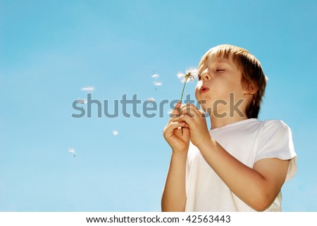 With dandelions in hands against the sky