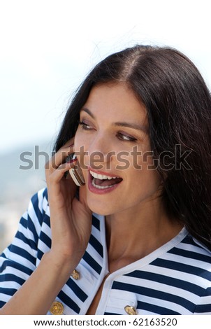 Closeup portrait of a smiling young beautiful woman talking on cellphone