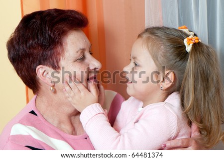 Closeup portrait of a grand daughter and grandmother smiling