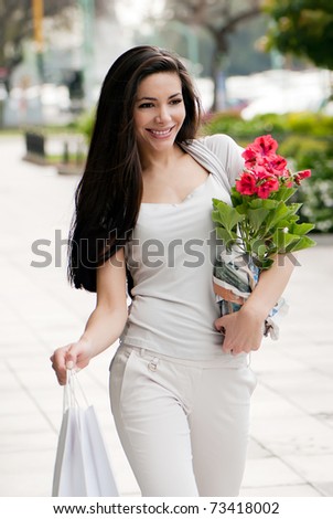 The beautiful young girl with a shopping Bag and flower