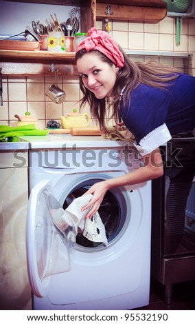young housewife with washing machine and towels.