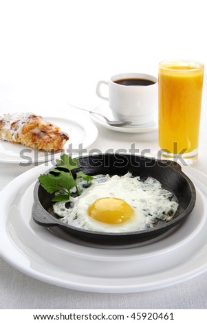 Fried eggs in frying pan, juice and coffee