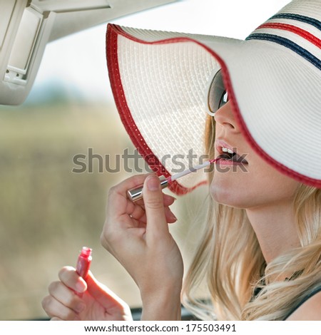 Pretty girl in a car - Cute blond woman makes up lips in the car