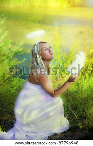 beautiful angel girl with magic fan in forest