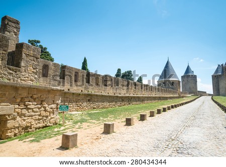 Walk way road in Ancient castle Carcassonne. Ancient fortress with towers and blue sky with clouds in background. Languedoc, France, Europe.