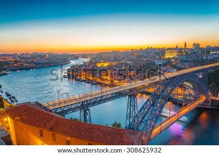 Panorama of lighted famous bridge Ponte dom Luis above Old town Porto and river Duoro at night, Portugal