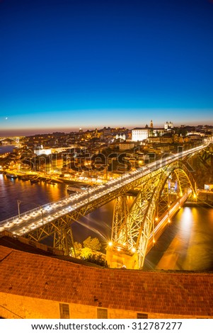 Panorama of lighted famous bridge Ponte dom Luis above Old town Porto and river Duoro at night, Portugal