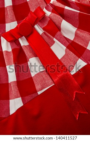 White and red cell textile texture with a red button and a bow on it/Cell textile background