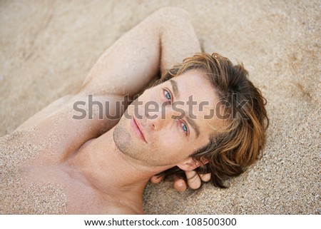 Over head view of an attractive man sunbathing on a beach.