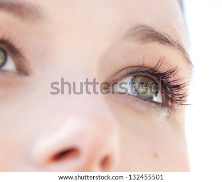 Close up beauty portrait of a young caucasian healthy woman face and eye looking up with long eyelashes.