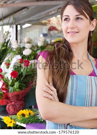 Portrait of a visionary business woman florist working at her flower market shop, standing with her arms crossed in front of her small business feeling hopeful, outdoors. Business lifestyle.