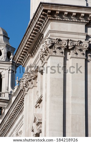 Close up detail view of an old stone building in the city of London with multiple intricate classic architecture design features, columns and roofs. Extensive building detail during a sunny day.
