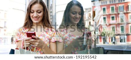 Panoramic portrait of a joyful young woman shopping in a city by a fashion store window with reflections, using a smartphone device to network outdoors. Consumerism and technology lifestyle.