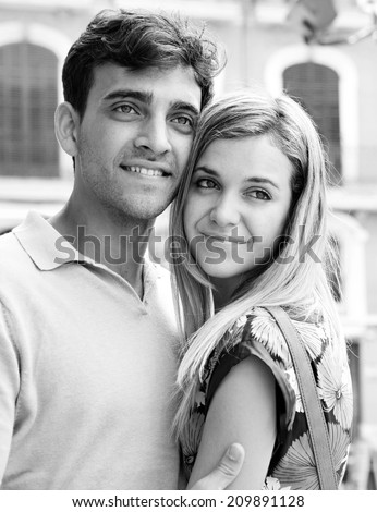 Black and white close up portrait of an attractive romantic tourist young couple relaxing and embracing while visiting a destination city on holiday together, outdoors. (Love, Lifestyle, outdoor)