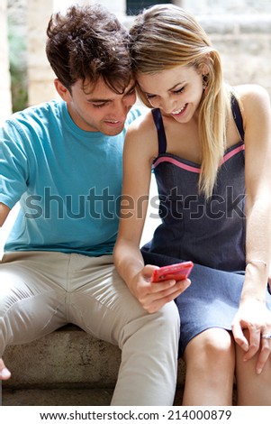 Portrait of a young attractive tourist couple using a smartphone to network while on holiday, visiting a touristic destination city and having fun outdoors. Sharing technology outdoors.