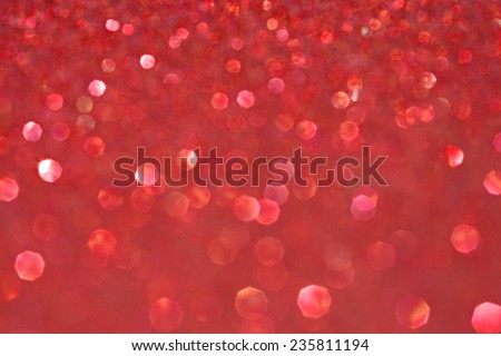 Abstract blurry red glitter festive background texture with shining glittering stars. Full frame magenta color christmas detail with blurred areas. Artistic colorful background drop frame space.