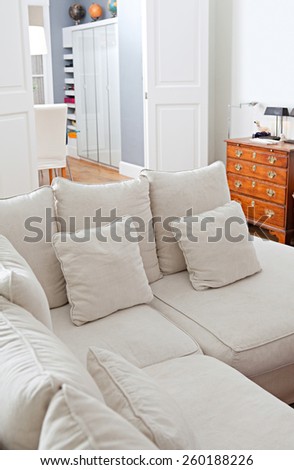 Still life interior design home living room view with a comfortable and welcoming white sofa with cushions, home interior detail. Aspirational and relaxing home family room, indoors living lifestyle.