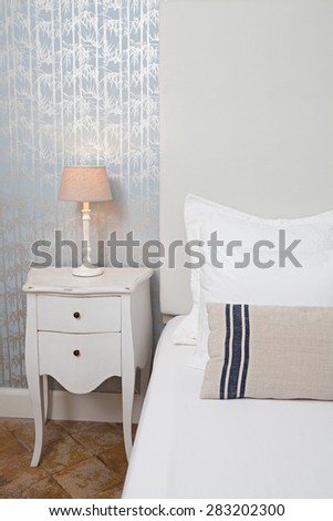 Still life view of luxury home bedroom with white and stripy pillows in a quality family home, interior design. Stylish aspirational lifestyle bedroom with a pattern wallpaper wall, indoors.