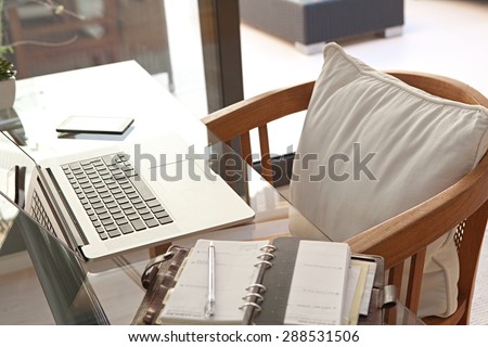 Still life of a home office room with a laptop computer and a smart phone, house interior. Working from home technology in a home work desk, indoors. High technology lifestyle workplace.