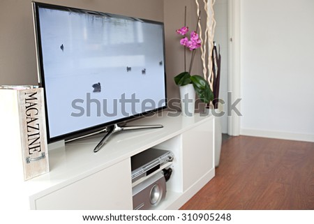 Still life view of a large home entertainment flat screen tv in a modern high technology house, interior. Elegant luxurious quality home cinema smart television with a blue screen, stylish indoors.