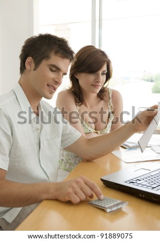 Man and woman working on finances at home.