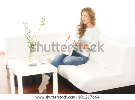 Young attractive woman with a parcel in modern interior